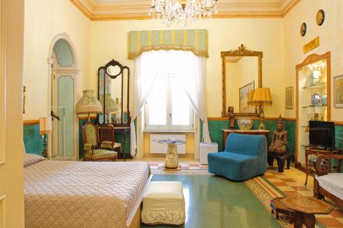 a bedroom with a bed and a blue chair at B&B Flora House in Salerno