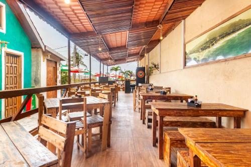 a row of wooden tables and chairs in a restaurant at Pousada Oencontro in Rio de Janeiro