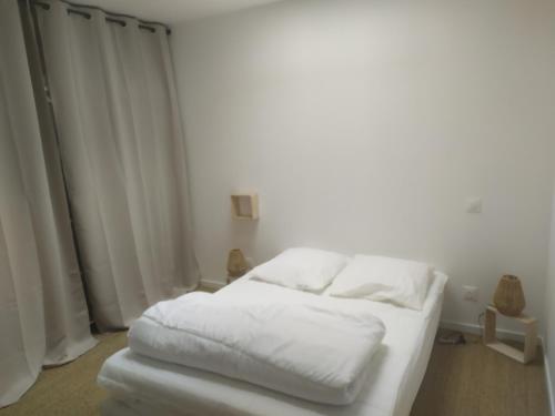 a white bed with white sheets in a room at Maison de vacances cosy à La Baule in La Baule