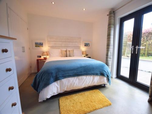 a bedroom with a bed and a large window at Sienna Cottage in Bradworthy