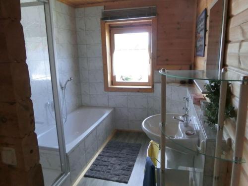 a bathroom with a tub and a sink at Holiday apartment Sterrenbergblick in Oberlenningen