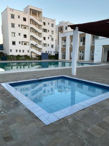 einem Pool vor einem Gebäude in der Unterkunft Serenity Haven, 1 BR, Pool, Wi-Fi, IPTV, Netflix, Air Conditioner in Mombasa