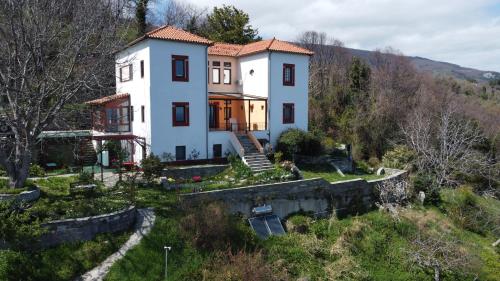 une grande maison blanche au sommet d'une colline dans l'établissement Sunray Luxury Apartment Zagora with piano, à Zagora