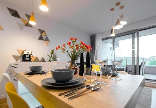 a dining table with wine glasses and a bowl on it at Apartview Bukowa II by Rent like home in Wisła