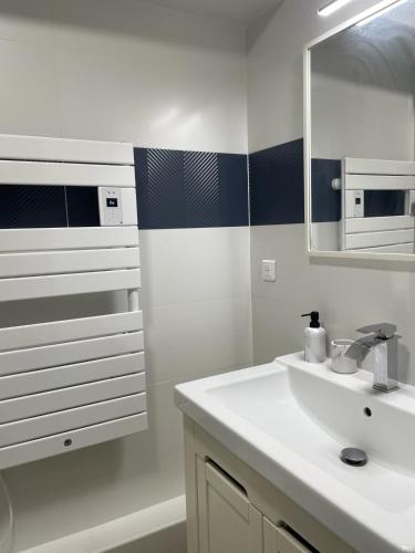 une salle de bain blanche avec un lavabo et un miroir dans l'établissement Triplex - 4 chambres - Centre historique, à Bourges