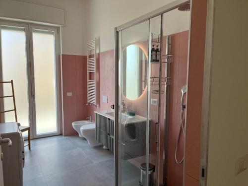 uma casa de banho com um chuveiro, um lavatório e um espelho. em Bocconi Navigli -La casa di Zoe with free Netflix and WiFi em Milão
