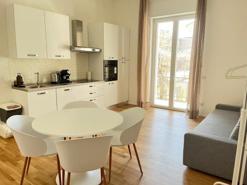 een keuken met een witte tafel en stoelen en een tafel bij Bocconi Navigli -La casa di Zoe with free Netflix and WiFi in Milaan