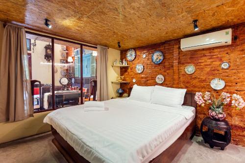 1 dormitorio con 1 cama grande y pared de ladrillo en Le Places Ancient Saigon 1975 D1 Ben Thanh Center en Ho Chi Minh