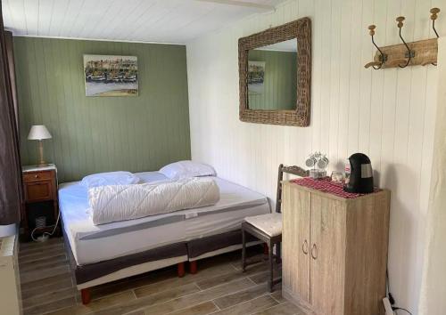une chambre avec un lit et un miroir au mur dans l'établissement Lofoten, à Le Touquet-Paris-Plage