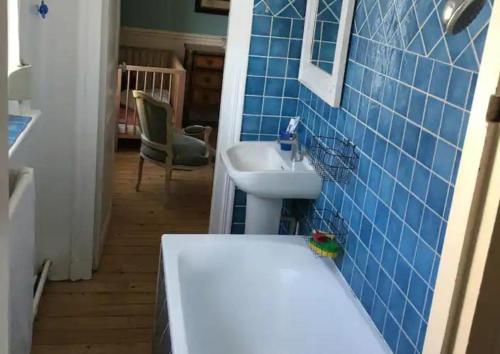 baño con lavabo blanco y pared de azulejos azules en Lofoten, en Le Touquet-Paris-Plage