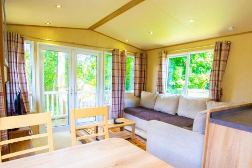 uma sala de estar com um sofá e algumas janelas em Hazel Glen 3 - Beauport Park - Hastings em Hastings