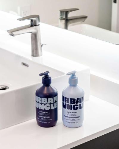 two bottles of hair punch sitting on a bathroom sink at YOTELPAD London Stratford in London