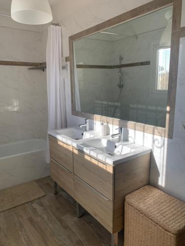 une salle de bain avec un lavabo et un grand miroir dans l'établissement Villa paradis, à Fréjus