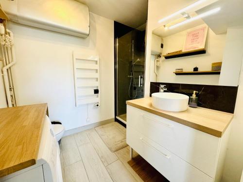 a white bathroom with a sink and a toilet at Le Nid du Parc in Dijon
