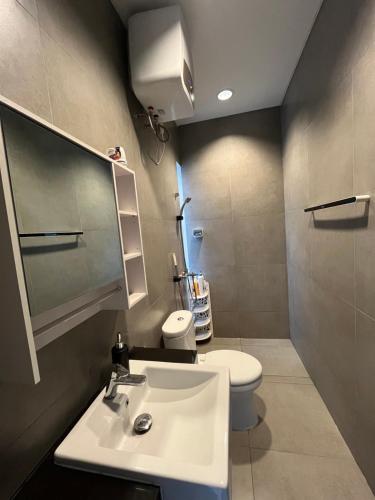 a bathroom with a white sink and a toilet at 2 Floor Cozy House in Wisteria Jakarta Garden City in Jakarta