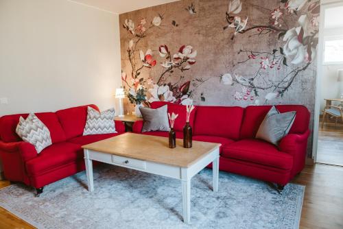 a living room with red couches and a coffee table at Best Western Valhall Park Hotell in Ängelholm