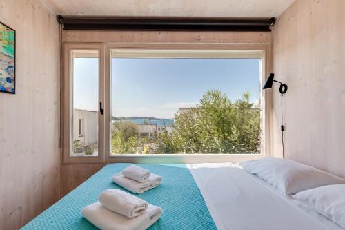 a bedroom with two towels on a bed with a window at BUQEZ ECO RESORT - Beach Villa 12 - Nice view in Drage