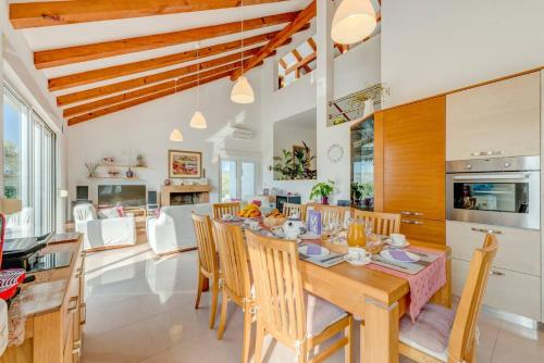 a kitchen and dining room with a wooden table and chairs at Rustic Villa Florice with a pool in Lećevica