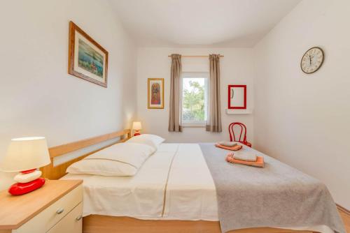 a bedroom with a large white bed and a window at Rustic Villa Florice with a pool in Lećevica