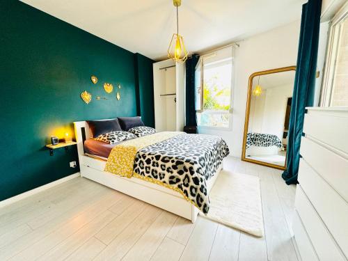 a bedroom with green walls and a bed with a cheetah blanket at Le Nid du Parc in Dijon
