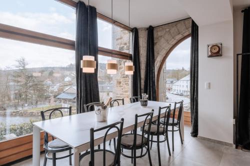 una sala da pranzo con tavolo, sedie e una grande finestra di Villa Madona a Tellin