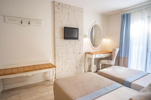 a bedroom with two beds and a desk and a mirror at Mark Warner Phokaia Beach Resort in Foca