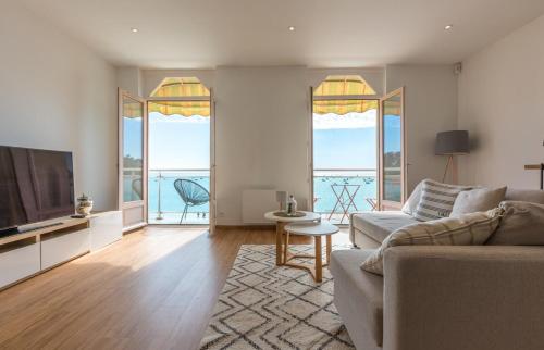 a living room with a couch and a television at Les Pieds Dans L'Eau - Bel appartement - Vue mer in Cancale