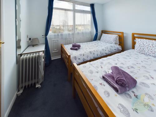 two beds in a room with a window at Lovely Chalet - Welcome Holiday Park Dawlish warren in Bellaghy