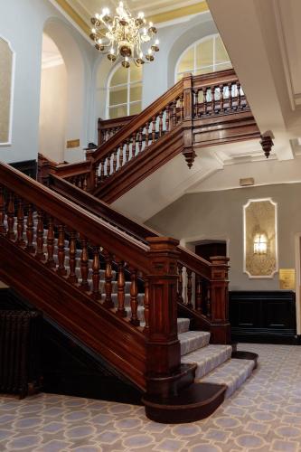 a large staircase in a building with a chandelier at Mercure Blackburn Dunkenhalgh Hotel & Spa in Blackburn