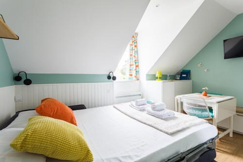 um pequeno quarto com uma cama e uma secretária em Le Petit Nid - Joli studio rénové - Plage à 5 min em Dinard