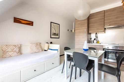 a living room with a bed and a dining table at Le Capucin - Petit duplex avec place de parking in Dinard