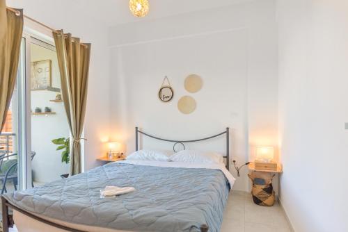 a bedroom with a bed with a blue comforter at Marvinas seaside apartments, Earth apartment & Ocean jacuzzi apartment in Kremasti