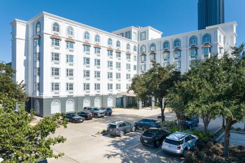 a large white building with cars parked in a parking lot at Hotel Vesper, Houston, a Tribute Portfolio Hotel in Houston