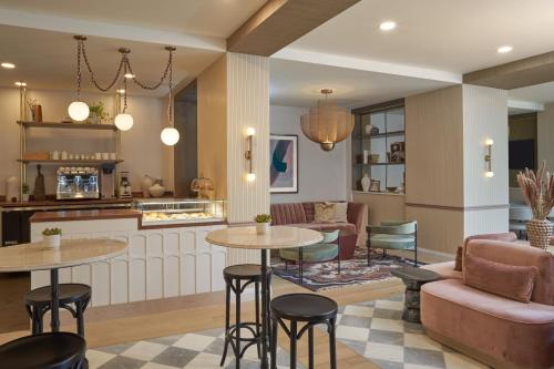 a kitchen and living room with tables and chairs at Hotel Vesper, Houston, a Tribute Portfolio Hotel in Houston