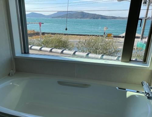 a bathroom with a white sink and a window at Villa 悠生凪 "yunagi" in Kose