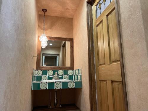 uma casa de banho com um lavatório, um espelho e uma porta em Sunset Villa 悠生凪 ”Yunagi” em Kose