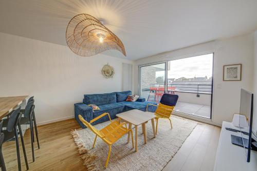 - un salon avec un canapé bleu et des chaises dans l'établissement Beaudelaire - Beau 2 chambres - Parking/Plage 400m, à Dinard