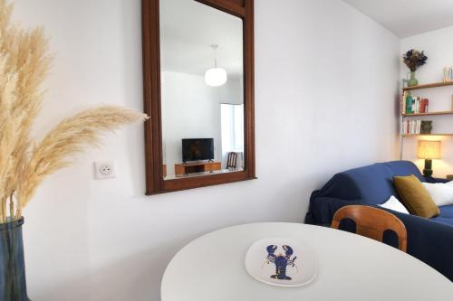 sala de estar con mesa blanca y espejo en Échappée Belle-Joli T2-Centre de Dinard-Plage 500m, en Dinard