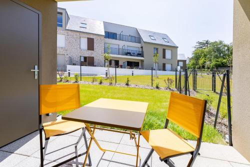 d'une table et de chaises sur un balcon avec une cour. dans l'établissement L'Equinoxe, T2 de plain-pied dans résidence neuve., à Saint-Malo