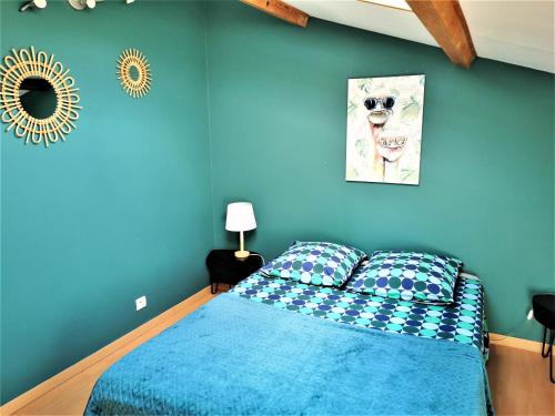 Dormitorio azul con cama y espejo en Villa de 6 chambres avec piscine privee jardin clos et wifi a Saint Bauzille de Montmel, en Saint-Bauzille-de-Montmel
