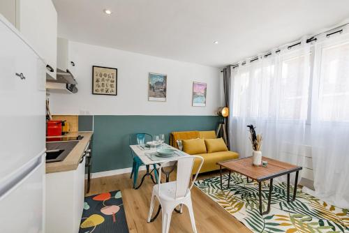 a living room with a table and a yellow couch at L'ANTHRACITE, apartement rénové, tout confort in Saint-Jacques-de-la-Lande