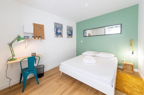 1 dormitorio con cama, escritorio y silla en L'ANTHRACITE, apartement rénové, tout confort, en Saint-Jacques-de-la-Lande