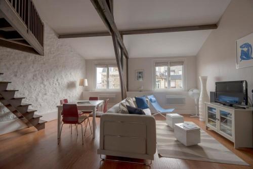 uma sala de estar com um sofá e uma mesa em L'Ancrage - Beau duplex 2 chambres - Plage à 5 min em Dinard