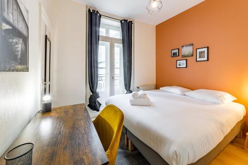 - une chambre avec un grand lit et une table en bois dans l'établissement Saint-Michel - T4 refait à neuf - Hyper centre, à Rennes