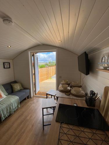 ein kleines Wohnzimmer mit einem Sofa und einem Tisch in der Unterkunft Cow Hill Pod in Fort William
