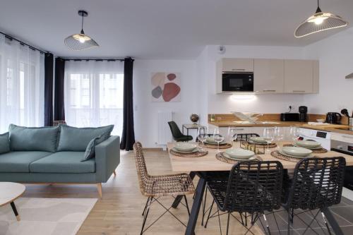 sala de estar con mesa y sofá azul en Le Normand- appartement neuf, 3 chambres, terrasse en Rennes