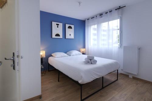 1 dormitorio con 1 cama grande y paredes azules en Le Normand- appartement neuf, 3 chambres, terrasse en Rennes