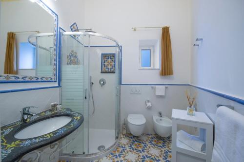 uma casa de banho com um lavatório, um WC e um chuveiro em Flatiron app 1 by Sosòre Holiday Homes - Amalfi Coast em Praiano
