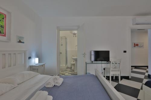 a white bedroom with a bed and a bathroom at Casa Galati in Palermo