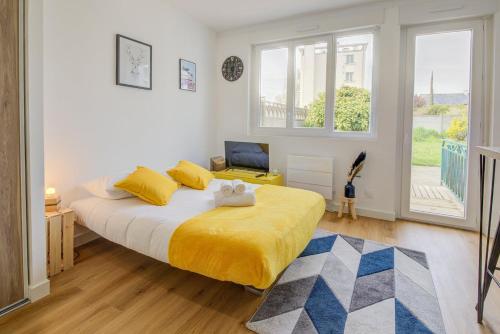 a bedroom with a large bed with yellow sheets at Le Yellow, studio rénové, tout confort, jardin in Saint-Jacques-de-la-Lande